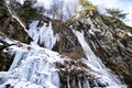 Icicle waterfalls sloping down a mountain side during a cold winter day