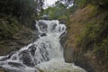 Between the mountain slopes a waterfall rages and foams on the stones.