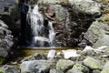 Small waterfall and blurred stream between rocks. Royalty Free Stock Photo