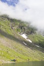 Mountain with snow by the lake in the summer