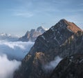 Mountain , snowy peaks above thick clouds against a blue sky Royalty Free Stock Photo