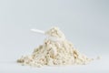 A mountain of soy protein isolate in powder with a measuring spoon on a white background. Royalty Free Stock Photo