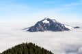 Mountain stick out of foggy cloud layer. Gruenten, Bavaria, Germany. Foresight and vision for business concept and ideas