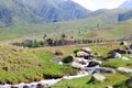 Mountain stream against the backdrop of village houses. Summer mountain landscape. Kyrgyzstan Royalty Free Stock Photo