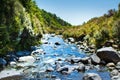 Mountain stream flowing over rocks amongst green banks Royalty Free Stock Photo