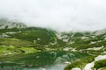 Mountain stream with view of rocky mountains and lake with transparent water Royalty Free Stock Photo