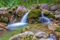 mountain stream with a waterfall and a small lake with rocks and moss Royalty Free Stock Photo