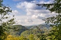 Mountain summer landscape. Hills covered with forest, against the background of clouds. Royalty Free Stock Photo