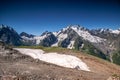 Mountain summit Dombai-Ulgen. In the background are glaciers and peaks of the Main Caucasus Range against the background of a Royalty Free Stock Photo