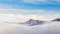 A mountain surrounded by fog in the autumn season