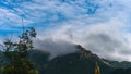 The mountain top is covered with dark clouds