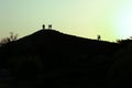 Mountain top in dusk as the sunset, people stand silhouetted against the sun Royalty Free Stock Photo