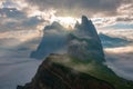 Mountain top peeks above the clouds, illuminated by the sun just after sunrise. Puez Odle-Geisler, Dolomite Alps, Italy