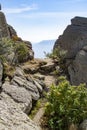 Mountain trail among the rocks against the backdrop of mountains and blue sky Royalty Free Stock Photo