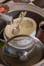 A mountain of unwashed utensils in a kitchen sink. Desolation and mess Royalty Free Stock Photo