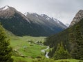 Mountain valley covered with pine trees, a river and houses in t
