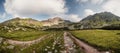 Mountain valley full of Wahlenbergovo lake and blooming flowers and a sidewalk leading to the valley. High Tatras national park , Royalty Free Stock Photo