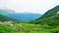 Mountain valley. Green grass, white stones and clouds