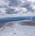 Mountain valley in snow under cloudy sky Royalty Free Stock Photo