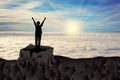 Mountain victory woman silhouette on top of rock above clouds 