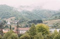 Mountain from view with small village and flow fog. Foggy summer morning in the mountains and a small village. Country road in the Royalty Free Stock Photo