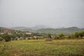 Mountain from view with small village and flow fog. Foggy summer morning in the mountains and a small village. Country road in the