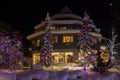 Mountain village after snowfall in night. Christmas illumination - trees, garlands and night lights, snow-covered houses, pine tre Royalty Free Stock Photo