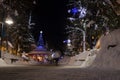 Mountain village after snowfall in night. Christmas illumination - trees, garlands and night lights, snow-covered houses, pine tre Royalty Free Stock Photo