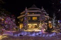 Mountain village after snowfall in night. Christmas illumination - trees, garlands and night lights, snow-covered houses, pine tre Royalty Free Stock Photo