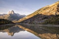 Mountain with water reflection in a lake with autumn tree forest and a small town in Aragon, Heusca, Spain Royalty Free Stock Photo
