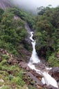 Mountain waterfall flowing out of the fog Royalty Free Stock Photo