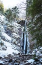 Mountain waterfall with rocks and cliffs covered with snow Royalty Free Stock Photo