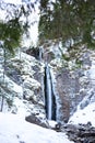 Mountain waterfall with rocks and cliffs covered with snow Royalty Free Stock Photo