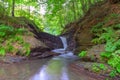 Mountain waterfall in the rocky canyon surrounded be green forest, cool and fresh nature summer landscape Royalty Free Stock Photo