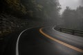 Mountain wet asphalt road curve at fog rainy day. Royalty Free Stock Photo