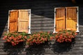 Mountain wooden chalet with windows and red geraniums - Italy Royalty Free Stock Photo