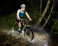 Mountainbiker driving through a streambed