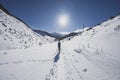 Mountaineer backcountry ski walking ski alpinist in the mountains. Ski touring in alpine landscape with snowy trees. Adventure win