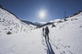 Mountaineer backcountry ski walking ski alpinist in the mountains. Ski touring in alpine landscape with snowy trees. Adventure win