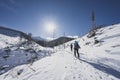 Mountaineer backcountry ski walking ski alpinist in the mountains. Ski touring in alpine landscape with snowy trees. Adventure win