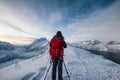 Mountaineer with backpack taking a photo a scenery on mountain peak