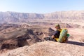 Mountaineer backpacker sitting resting mountain edge stone desert