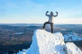 The mountaineer climbed the mountain top covered with ice and snow, man hiker standing at the peak of rock and Royalty Free Stock Photo