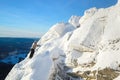 The mountaineer climbing the mountain top covered with ice and snow, man hiker going at the peak of rock. Winter season. Royalty Free Stock Photo