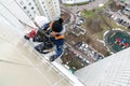 Mountaineer employee of public services warms the facade of residential building.