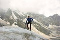 The mountaineer with the ice ax stands on top of the glacier. Royalty Free Stock Photo