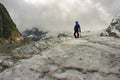 The mountaineer with the ice ax stands on top of the glacier Royalty Free Stock Photo