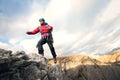 Mountaineer jumps over rocks in mountin