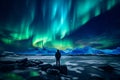 The mountaineer looks admiringly at the northern lights or Aurora phenomenon.