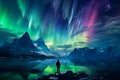 The mountaineer looks admiringly at the northern lights or Aurora phenomenon.